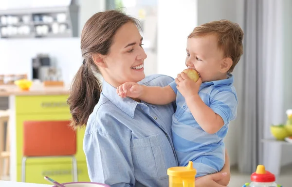 Junge Frau hält ihr Baby zu Hause — Stockfoto