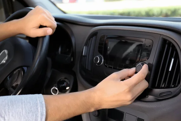 Man tuning car radio