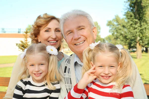 Älteres Ehepaar mit Enkelinnen im Park — Stockfoto