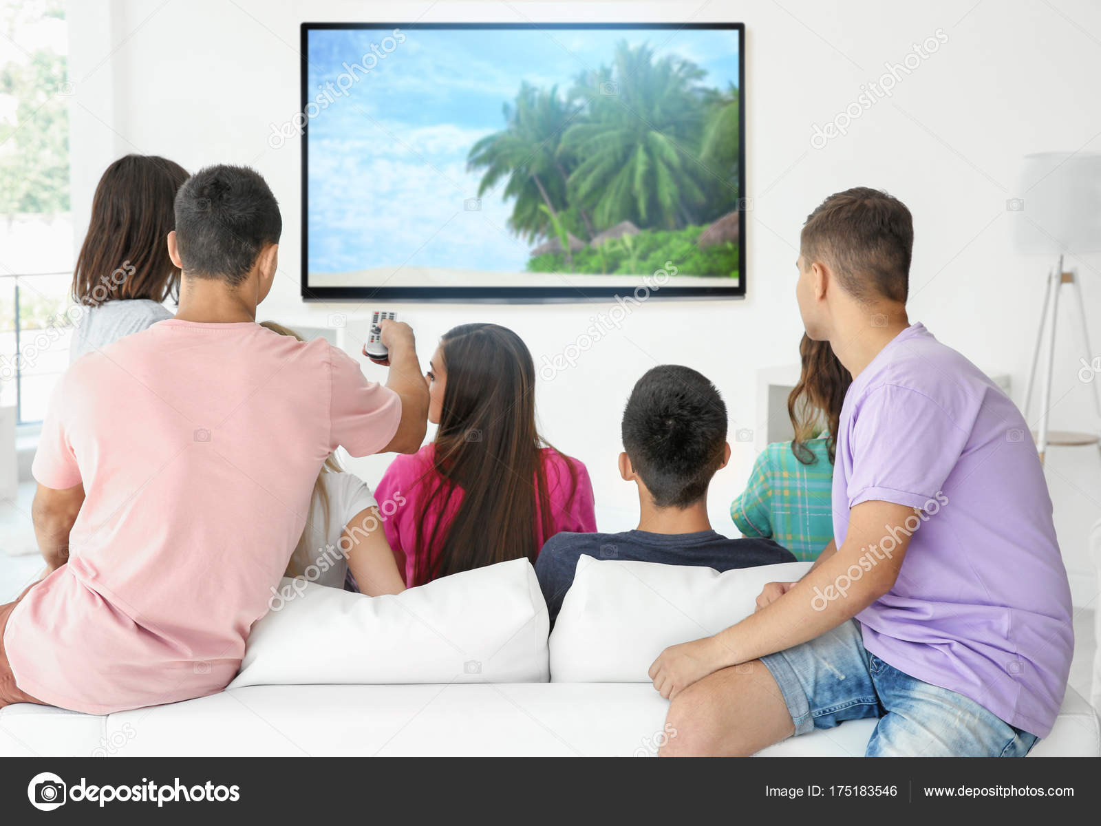 Foto de Dois Amigos Sorridentes No Sofá Assistindo Tv Juntos No Escuro e  mais fotos de stock de Assistir TV - iStock