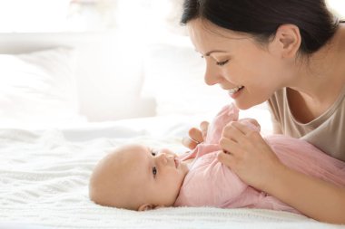 Genç anne ile bebek evde yatakta
