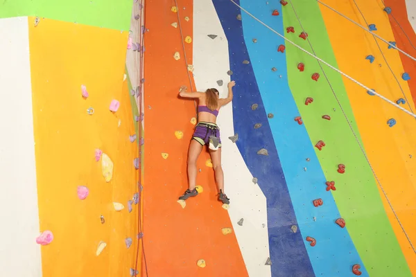 Mujer joven haciendo ejercicio en el gimnasio de escalada — Foto de Stock