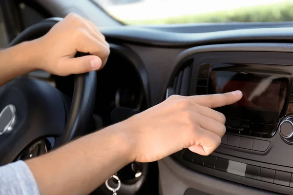 Man tuning car radio