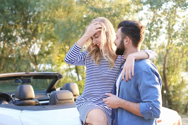 Szczęśliwa para młodych, przytulanie w pobliżu samochodu — Zdjęcie stockowe
