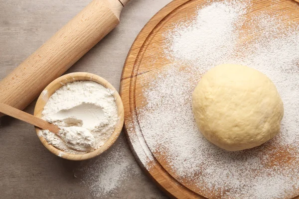 Raw dough on wooden board — Stock Photo, Image
