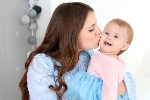 Jovem mãe beijando bebê bonito em casa — Fotografia de Stock