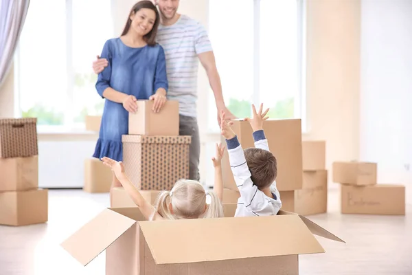 Frères et sœurs avec leurs parents qui s'amusent dans leur nouvelle maison — Photo