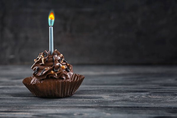 Tasty chocolate cupcake with candle