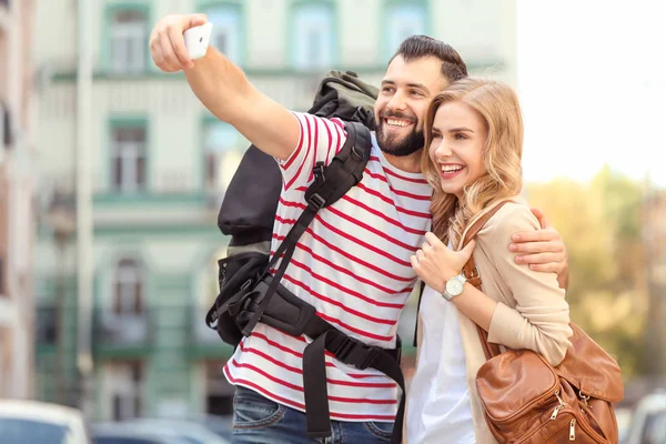 Un par de turistas jóvenes tomando selfie en la calle — Foto de Stock