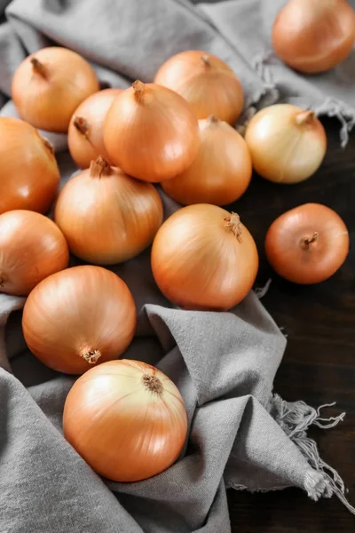 Fresh raw yellow onion on fabric — Stock Photo, Image