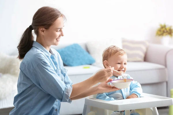 Mujer alimentando a su bebé en casa — Foto de Stock