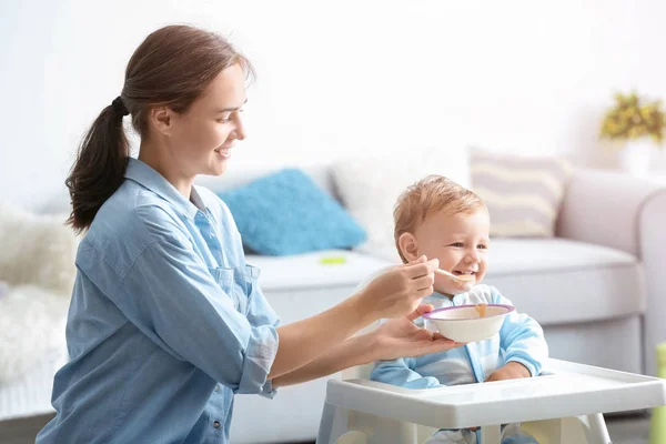 Mulher alimentando seu bebê em casa — Fotografia de Stock