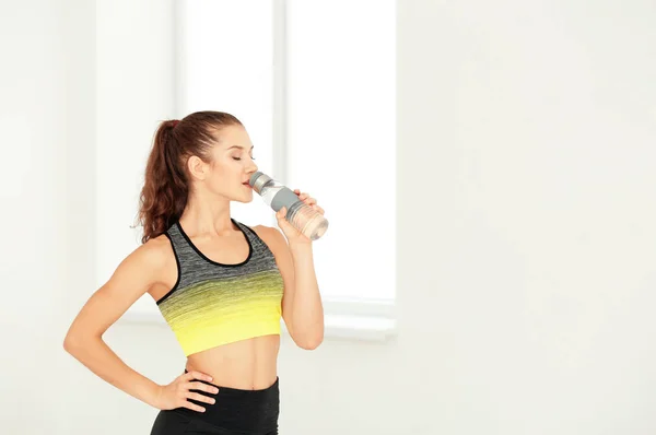 Deportiva joven bebiendo agua en casa — Foto de Stock