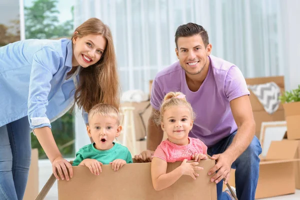Família feliz com caixa em movimento em sua nova casa — Fotografia de Stock