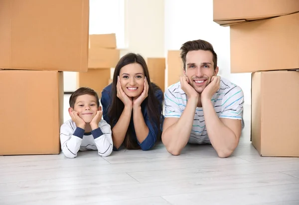 Família deitada no chão em sua nova casa — Fotografia de Stock