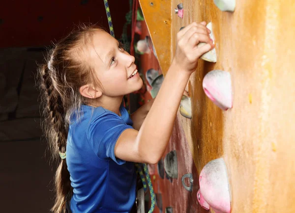 Niña escalando en la pared en el gimnasio — Foto de Stock