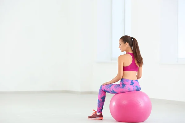 Sportieve jonge vrouw zittend op fitball thuis — Stockfoto