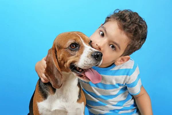 Милий хлопчик з собакою на кольоровому фоні — стокове фото