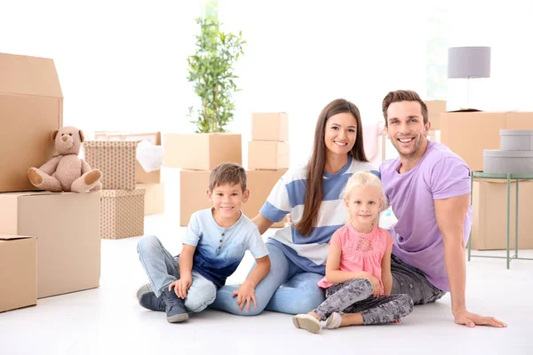 Zittend op de vloer in hun nieuwe huis en gelukkige familie — Stockfoto