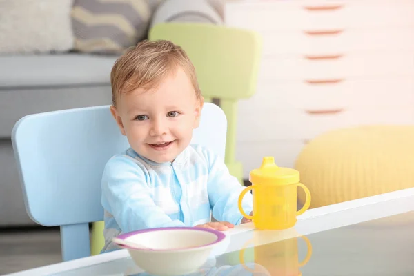 Adorable bebé sentado en la mesa en el interior —  Fotos de Stock