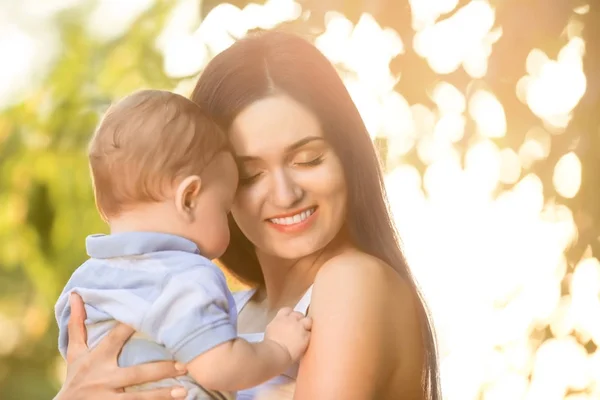 Ibu muda yang cantik menggendong bayi laki-laki lucu, di luar ruangan — Stok Foto