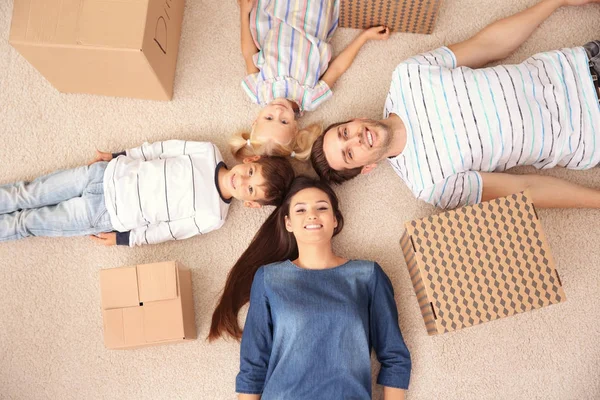 Familia acostada en el suelo en su nuevo hogar — Foto de Stock