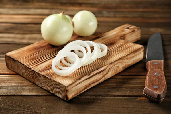 Cutting board with fresh onion and knife — Stock Photo, Image