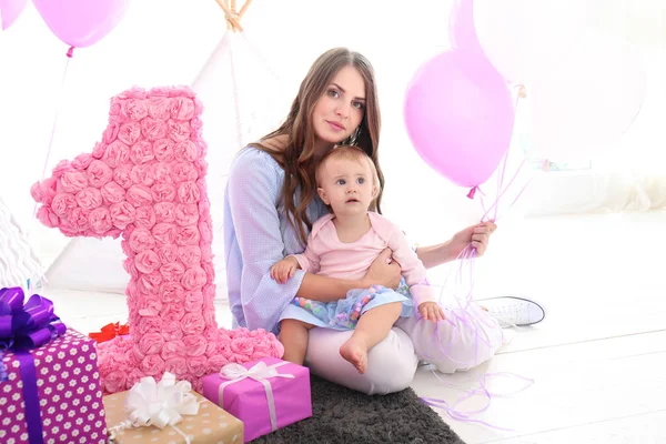 Junge Mutter und süßes Baby mit Geburtstagsgeschenken zu Hause — Stockfoto