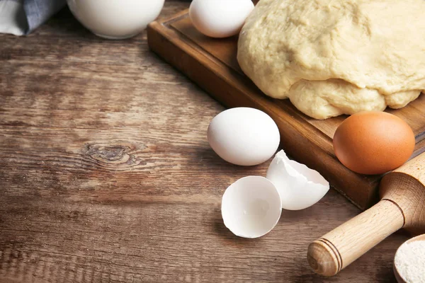 Сырое тесто и яйца на кухонном столе — стоковое фото