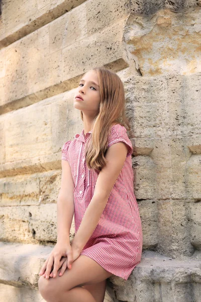 Маленька модна дівчинка біля старої будівлі на відкритому повітрі — стокове фото