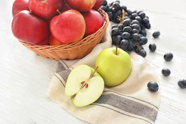 Состав с яблоками и виноградом на деревянном столе — стоковое фото