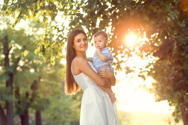 Vacker ung mamma innehav söt baby pojke, Utomhus — Stockfoto