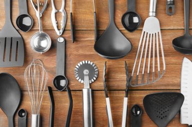 Various kitchen utensils on wooden background clipart