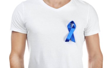 Beyaz arka plan üzerinde sembolik mavi kurdele ile t-shirt genç adam. Kanser farkındalık kavramı