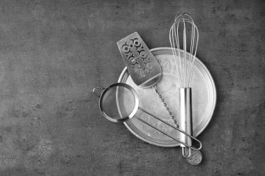 Gri dokulu arka plan üzerinde çeşitli mutfak eşyaları