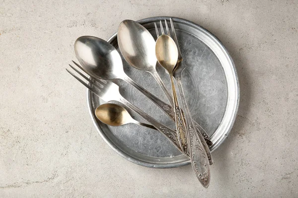 Vintage plate and cutlery on light textured background — Stock Photo, Image