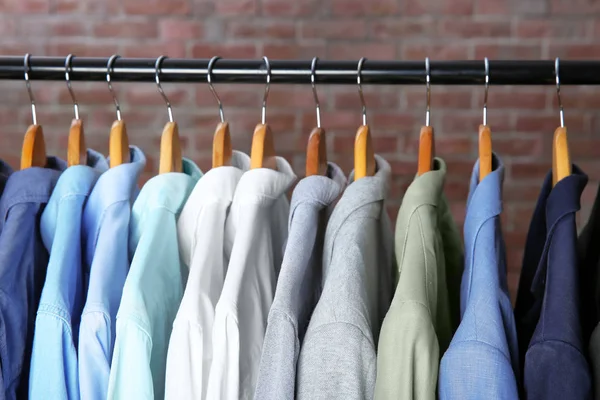 Куртки и рубашки, висящие на перилах одежды — стоковое фото