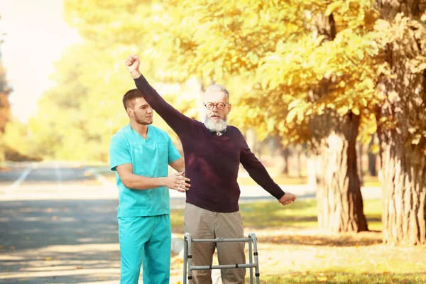 Opiekun spaceru z starszy mężczyzna — Zdjęcie stockowe