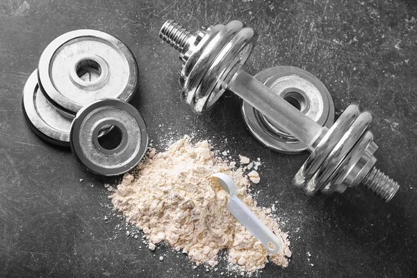 protein powder with scoop, dumbbell and disks