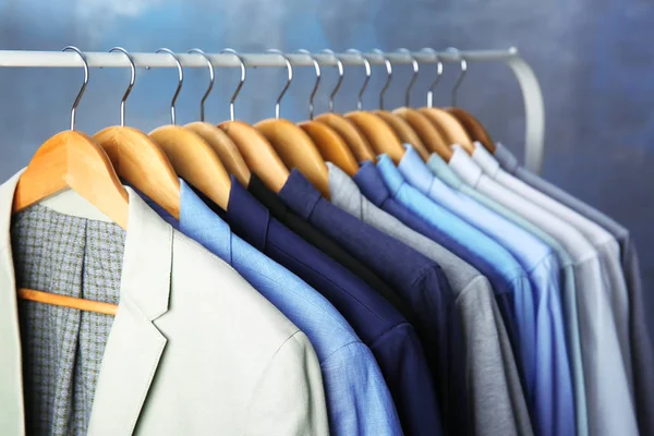 Chaquetas y camisas que cuelgan del carril de la ropa — Foto de Stock