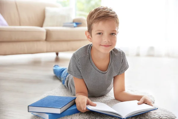 Lindo niño leyendo en el suelo en casa — Foto de Stock