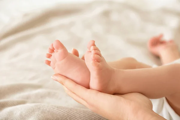 Mãe segurando pés de bebê — Fotografia de Stock