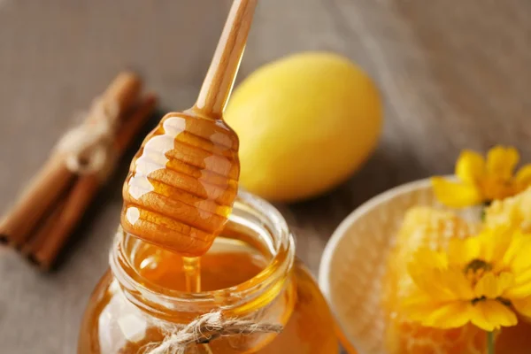 Pouring aromatic honey into jar — Stock Photo, Image