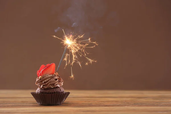 Tasty chocolate cupcake with sparkler — Stock Photo, Image