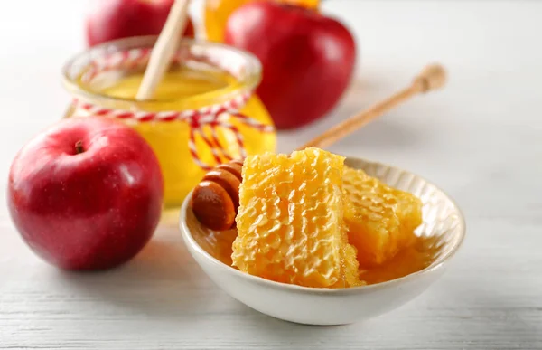 Honeycomb in bowl and apple — Stock Photo, Image