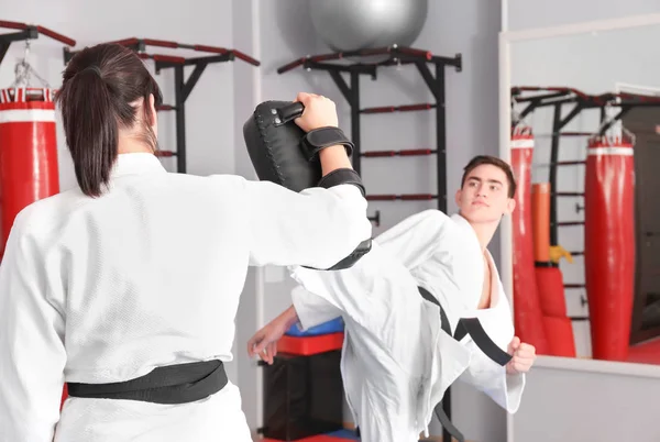 Jovem e mulher praticando karatê — Fotografia de Stock