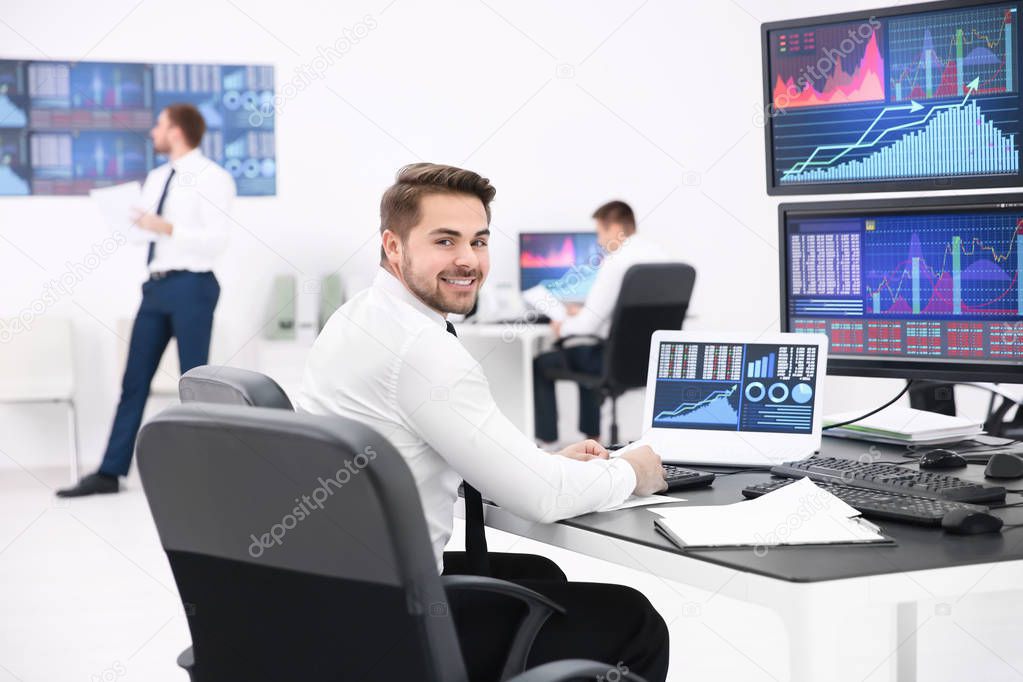 Male stock trader working in office