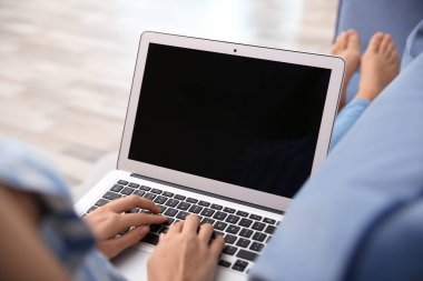 Evde Dizüstü bilgisayar kullanan kadın