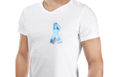 Beyaz arka plan üzerinde sembolik mavi kurdele ile t-shirt genç adam. Kanser farkındalık kavramı
