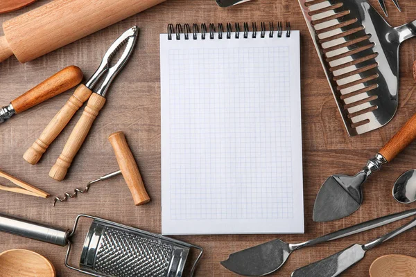 Notebooky a různé kuchyňské náčiní dřevěné pozadí — Stock fotografie